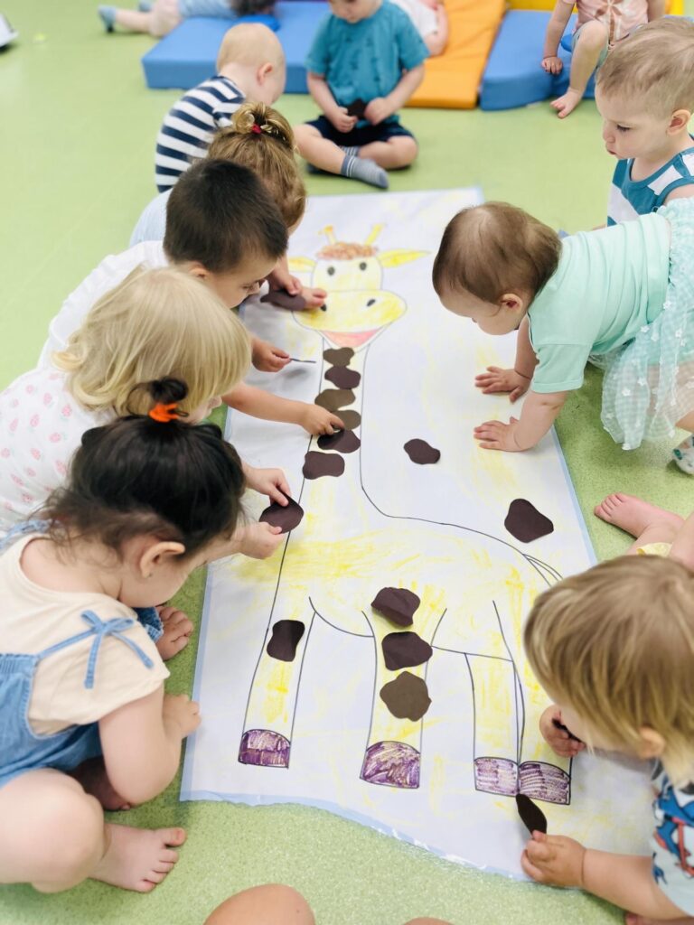 dzieci wyklejają żyrafę